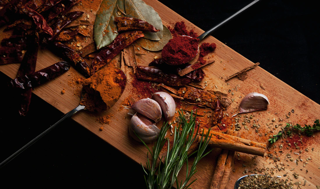 Spices and garlic arranged on a wooden board